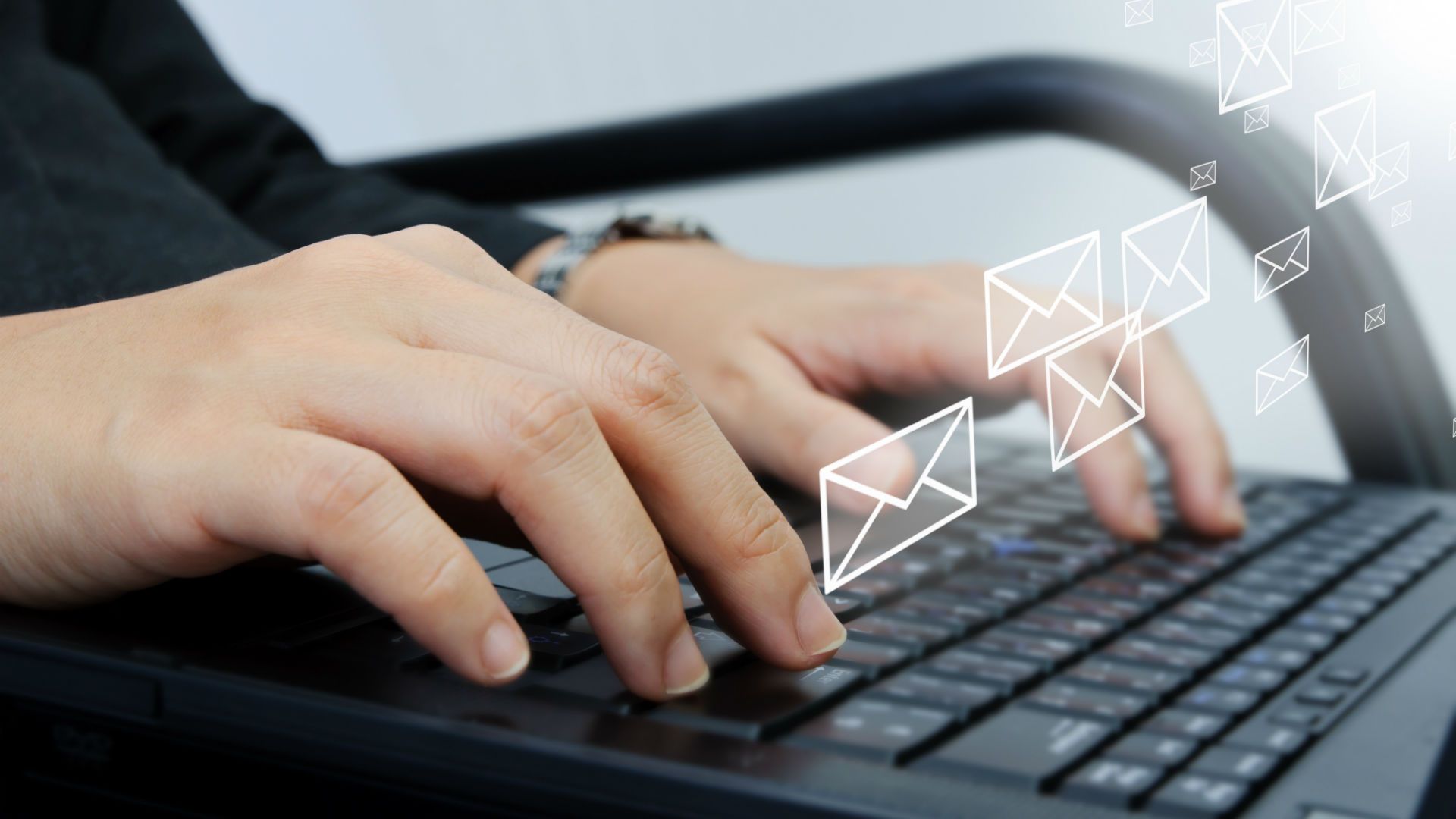 Hands typing an email subject line on a laptop keyboard